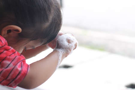 cute girl washing her hand and playing with buble. Selective focusの写真素材