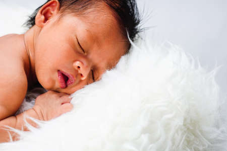 Close up new born baby sleeping on furry cloth. Parenting concept. Motherhoodの写真素材