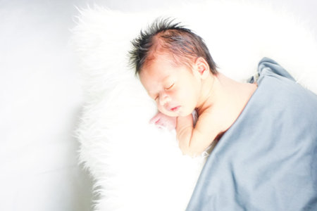 Close up new born baby sleeping on furry cloth. Parenting concept. Motherhood