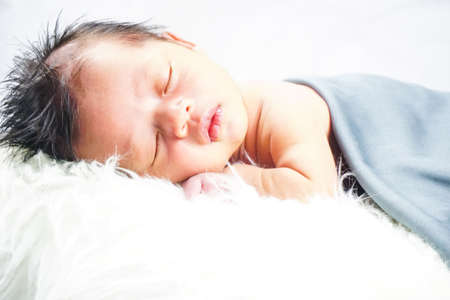 Close up new born baby sleeping on furry cloth. Parenting concept. Motherhoodの写真素材