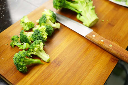 Close up broccoli with kitchen knife on a cutting board. Lunch cooking preparation concept.の写真素材