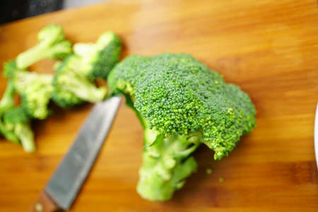 Close up broccoli with kitchen knife on a cutting board. Lunch cooking preparation concept.の写真素材