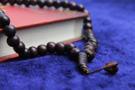 Close up Holy Quran with tasbih or muslim beads rosery over a praying mat. Ramadan Kareem