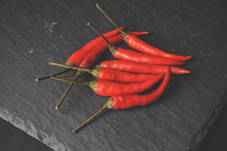 Chillies on slate, stone grunge texture. Vintage tone. Food Copy Space