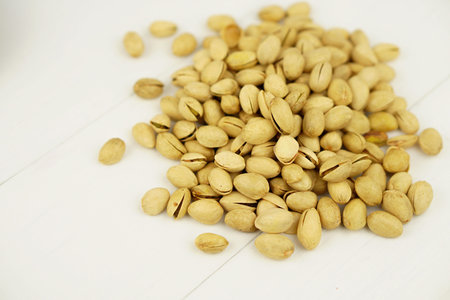 Close up Pistachio on white wooden background and spoon. Selective focus. Copy Space