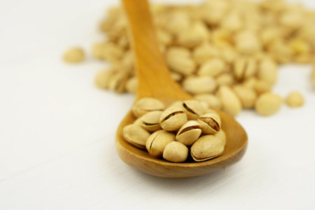 Close up Pistachio on white wooden background and spoon. Selective focus. Copy Spaceの写真素材