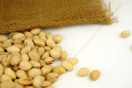 Close up Pistachio on white wooden background and spoon. Selective focus. Copy Spaceの写真素材