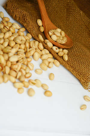 Close up Pistachio on white wooden background and spoon. Selective focus. Copy Spaceの写真素材