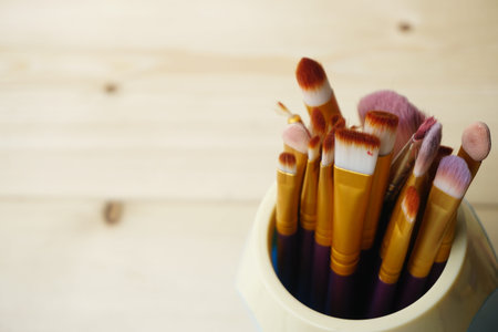 Make up brushes in wooden box. Copy Space Concept