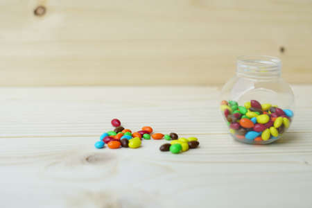 Colorful Candies Chocolate inside a jar over wooden backgroundの写真素材
