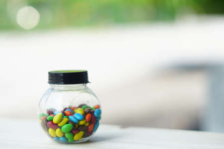 Colorful Candies Chocolate inside a jar over wooden backgroundの写真素材