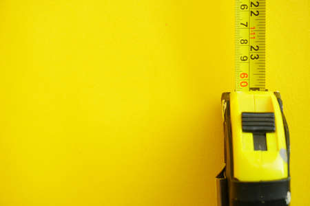 Close up ellow Measuring Tape over bright yellow background. Selective Focus, Copy Spaceの写真素材