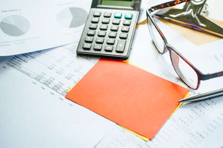 Financial calculation numbers chart with pen, calculator, glass, and notes. Selective Focusの写真素材