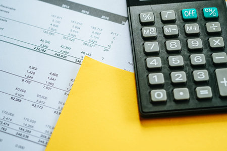 Financial calculation numbers chart with pen, calculator, glass, and notes. Selective Focusの写真素材