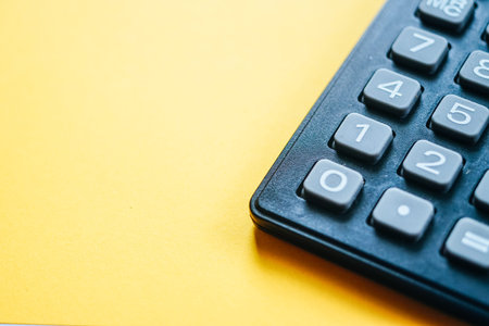 Close up a calculator over yellow background. Financial Calculation Concept.の写真素材