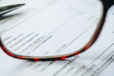 Financial calculation numbers chart with pen, calculator, glass and  notes. Selective Focusの写真素材
