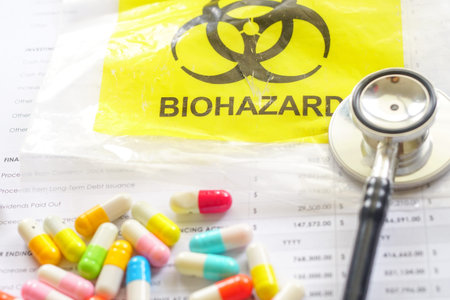 Colorful Medical capsules and pills on a paper with Bio Hazard container and stethoscope.