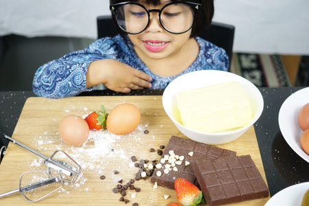 Sweet little cute girl is learning how to make a cake, in the home kitchen, Family concept,