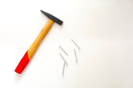 Wooden hammer with nails isolated white backgroundの写真素材