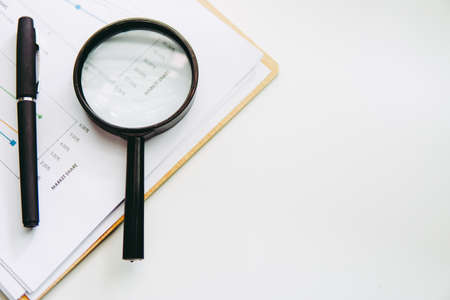Financial Concept of Magnifying Glass, pen over a Statistic Graph Chartの写真素材