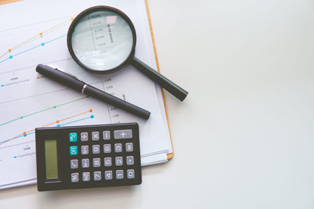 Financial Concept of Magnifying Glass, pen over a Statistic Graph Chartの写真素材