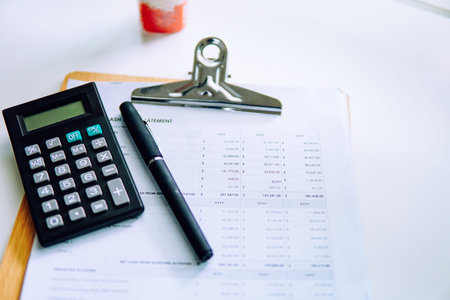 Business Meeting Scene, calculator, black pen and report graph on a white background.