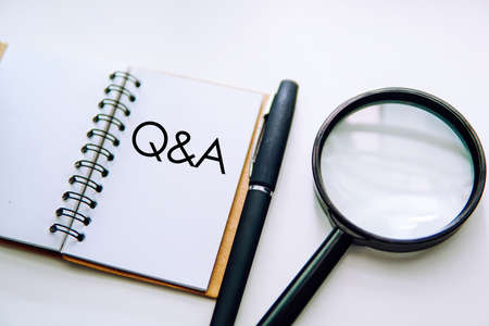 Q & A word on a notebook with black pen and magnifying glass over white background. FAQ Conceptの写真素材