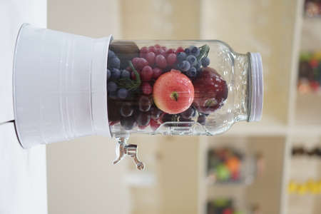 Fresh Fruits Apple and grape inside a dispenser glass jar. Healthy Food Lifestyle. Infuse Water. Selective Focusの写真素材