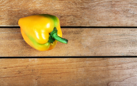 Yellow bell pepper on wooden tableの写真素材