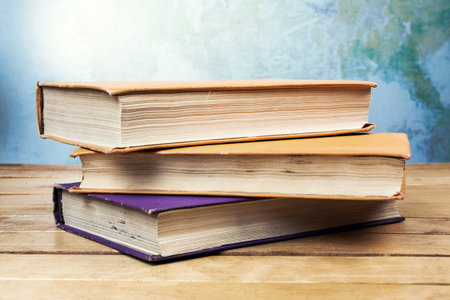 Three vintage old books on wooden table