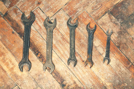 Set of old rusty wrenches on wooden floorの写真素材