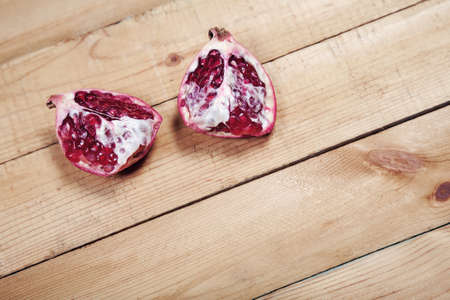 Parts of pomegranate on wooden backgroundの写真素材