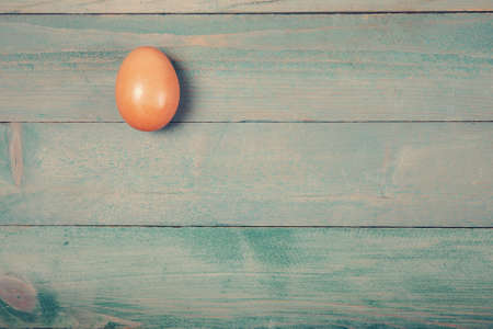 Raw chicken egg on wooden table with copy spaceの写真素材