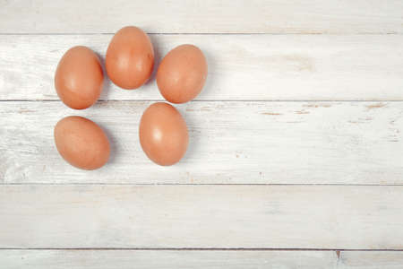 Raw chicken eggs on white wooden backgroundの写真素材