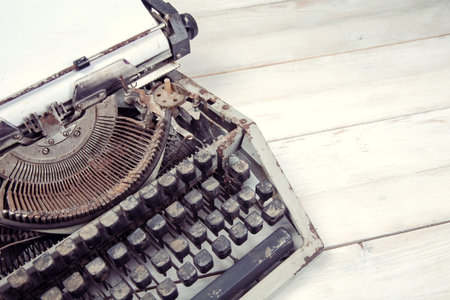 Dirty vintage typewriter on white wooden table