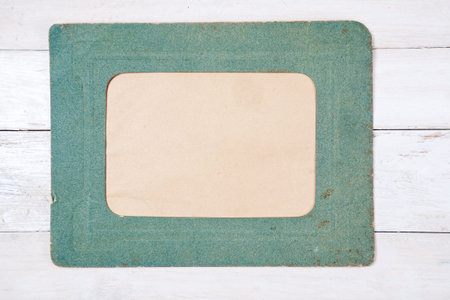 Retro green photo frame on white wooden background. Top viewの写真素材