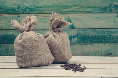 Coffee beans with burlap sacks over old wooden backgroundの写真素材