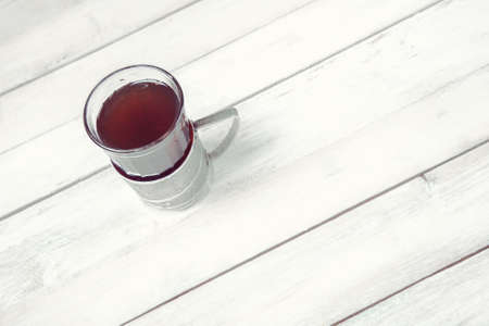 Cup of tea in vintage glass-holder on white wooden backgroundの写真素材