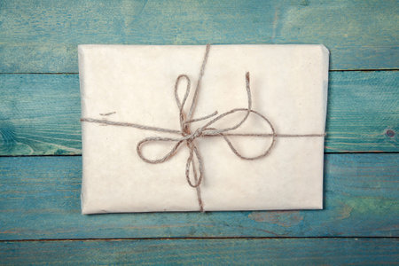 Paper wrapped package on old, blue wooden backgroundの写真素材