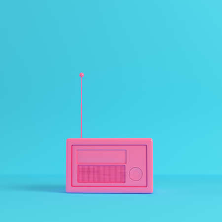 Pink retro styled radio on bright blue background in pastel colors.の写真素材