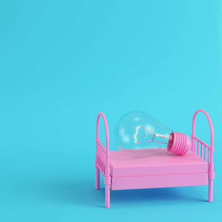 Pink single bed with glowing light bulb on bright blue background in pastel colors. Minimalism concept. 3d renderの写真素材