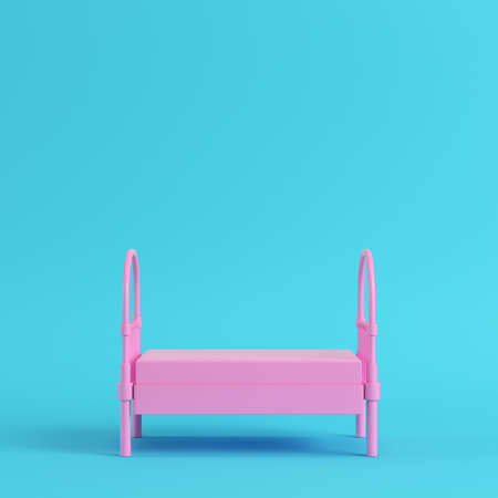 Pink single bed on bright blue background in pastel colors. Minimalism concept. 3d renderの写真素材