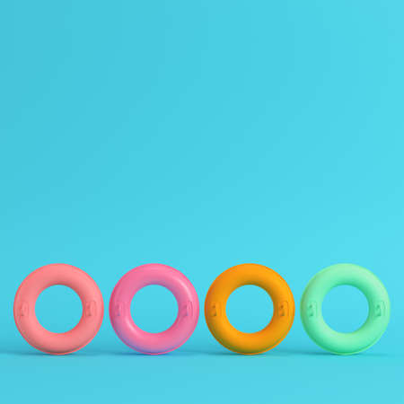 Four colorful inflatable rings on bright blue background in pastel colors. Minimalism concept. 3d renderの写真素材