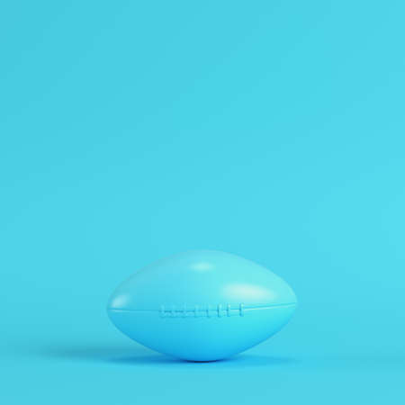 American football ball on bright blue background in pastel colors. Minimalism concept. 3d renderの写真素材