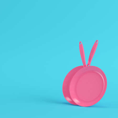 Pink frying pans on bright blue background in pastel colors. Minimalism concept. 3d renderの写真素材