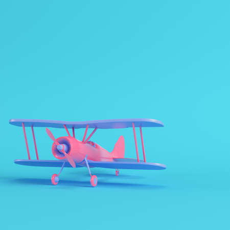 Pink biplane on bright blue background in pastel colors. Minimalism concept. 3d renderの写真素材