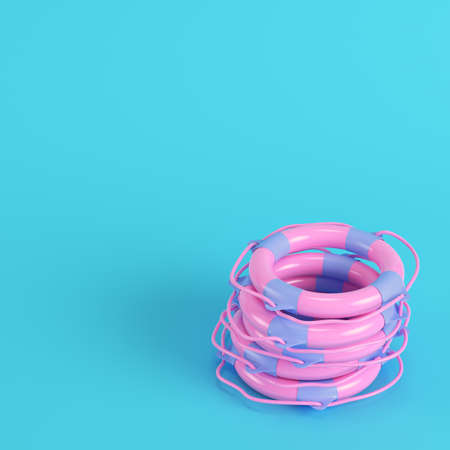 Pink stack life buoys on bright blue background in pastel colors. Minimalism concept. 3d renderの写真素材