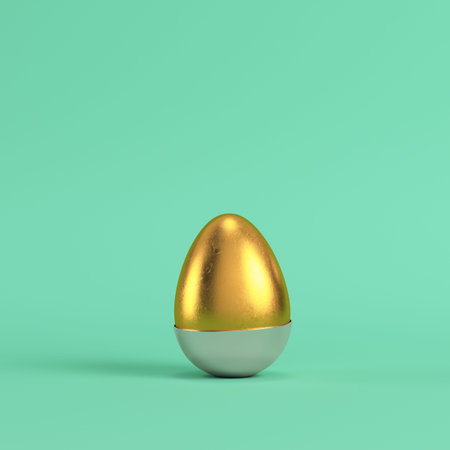 Golden egg with bottom part of silver shell on bright green background in pastel colors. Minimalism...
