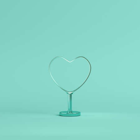 Metal heart shape with stand on bright green background in pastel colors. Minimalism concept. 3d renderの写真素材