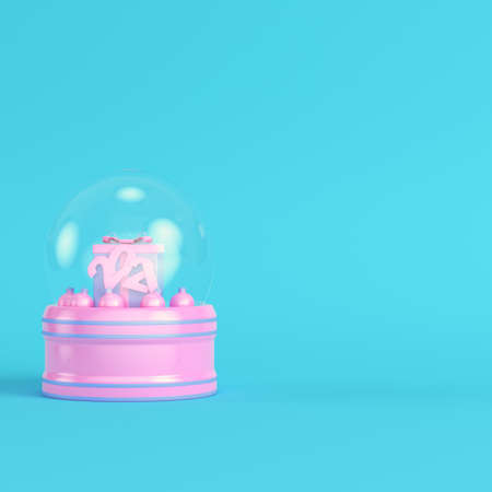 Pink snow globe with present box, christmas baubles and 2021 figures on bright blue background in pastel colors. Minimalism concept. 3d renderの写真素材